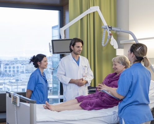 Patientin bei Visite im Krankenbett